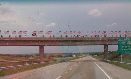 Group photo of people on a bridge holding American flags